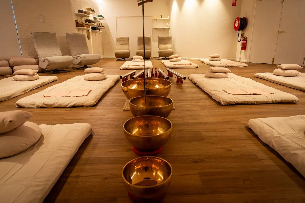 Rows of mats in the sound studio with singing bowls glowing in the foreground